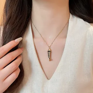 Detailed shot of a stylish fish pendant necklace worn by a female model.