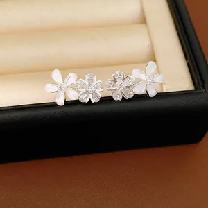 Gros plan détaillé de boucles d'oreilles fleurs avec pétales en résine et zircons brillants