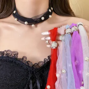 Close-up detail of colorful mesh necklaces with pearls and magnetic diamond clasps