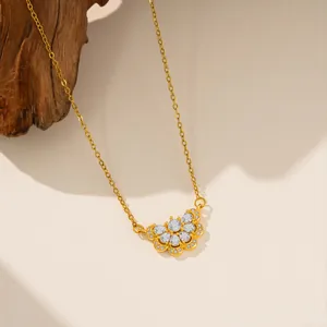 Primer plano de collar de acero de titanio dorado con colgante de flor de circón