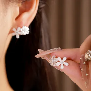 Vue détaillée de boucles d'oreilles en argent avec fleurs en zircone et résine