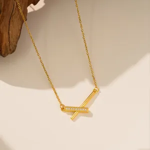 Detalle de un elegante collar de acero titanio con colgante cruzado de circón