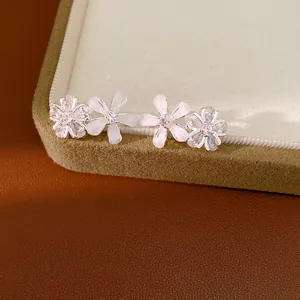 Gros plan détaillé de boucles d'oreilles fleur en zircone et résine sur un coffret