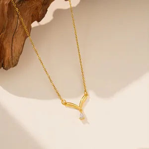 Detalle en primer plano de un elegante collar de acero de titanio dorado con V
