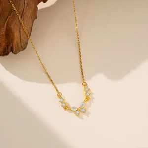 Vista detallada de un colgante de mariposa dorado con piedras de circonita brillantes.