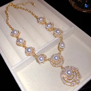 Nahaufnahme einer Vintage-Goldkette mit geschichtetem Perlenanhänger in der Schmuckschatulle.