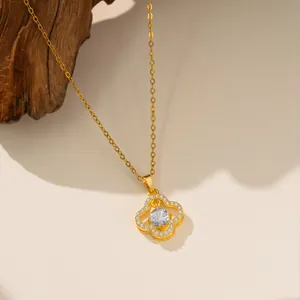 Vista detallada de un collar de acero de titanio dorado con un colgante de trébol de circón