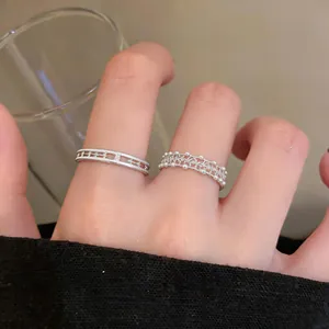 Elegant detail of silver lace double-layer ring and delicate pearl bead band on a finger.