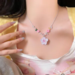 Detailed view of beaded resin cherry blossom necklace on model's neck for summer.