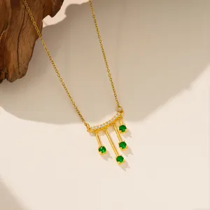 Vista detallada del elegante collar de acero inoxidable dorado con circonitas verde esmeralda