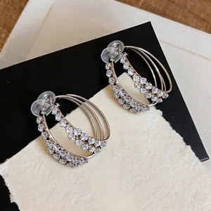 Macro view of elegant silver-toned double-layer circular earrings with sparkling zircon inlays