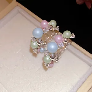 Close-up of elegant silver hoop earrings with pastel pearls and sparkling zircons