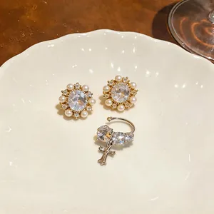 Close-up of 14k gold plated French retro zircon and pearl earring set on a ceramic dish