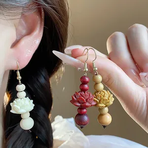 Close-up detail of handcrafted lotus flower wood bead drop earrings in three vibrant colors