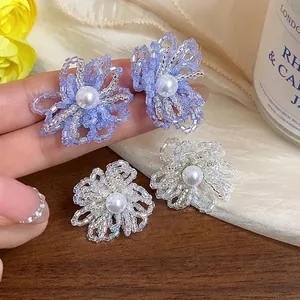 Pendientes de flores de cuentas de vidrio en morado y blanco con perla central