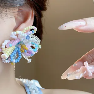 Macro view of colorful dopamine style beaded flower earrings showing intricate craft details