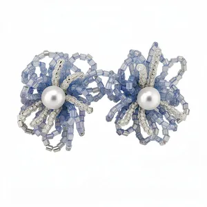 Elegantes pendientes de flores de cristal azul con una perla central y toques plata