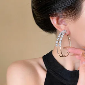 Close-up detail of double layered silver hoop earrings with sparkling square zircons.