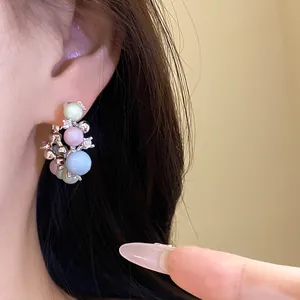 Detailed view of fashionable pastel bead hoop earrings with silver needles and zircon