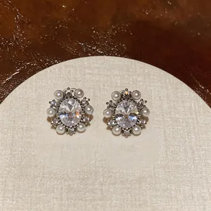 Close-up detail of vintage-style zircon and pearl clip-on earrings on display