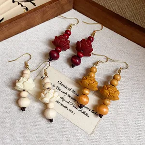 Detailed close-up of retro Chinese style wooden lotus bead earrings in three colors