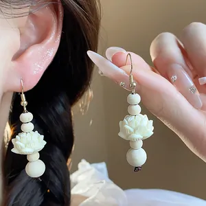 Close-up of retro Chinese style wooden bead earrings with carved white lotus