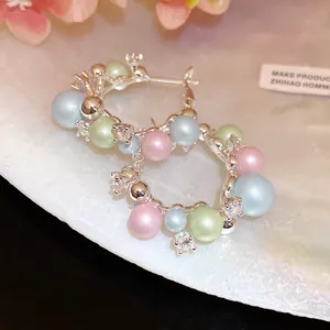 Detail showing colorful pearls and clear zircons on silver hoop earrings