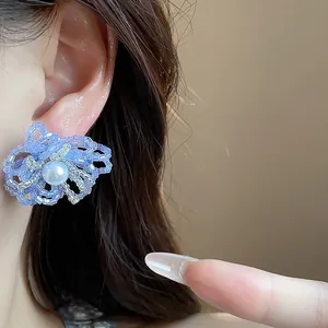 Primer plano de pendientes de flores hechos a mano con perlas lavanda.