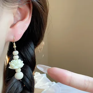 Close-up of vintage Chinese style lotus flower drop earring with wooden beads