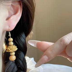 Detail shot of vintage Chinese style wooden bead earrings with a hand-carved lotus flower design