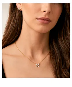 Model met een goudvergulde roestvrijstalen vlinder hanger ketting en oorbellen set