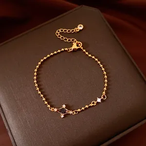 Detailed view of a gold beaded star bracelet with zircon inlay on a luxury jewelry box