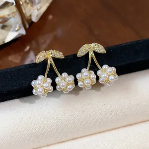 Primo piano di orecchini a lobo a ciliegia in stile francese con zirconi e perle.