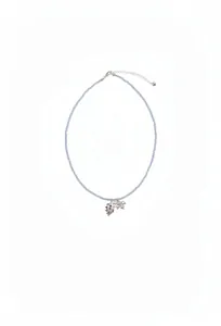 Détail du collier de perles bleu clair avec pendentifs raisin violet et papillon argenté