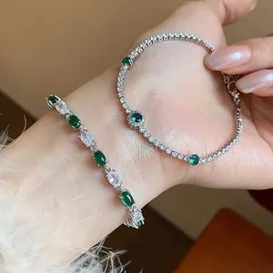 Close-up detail showing sparkling green and white zircon bracelets on a model's wrist