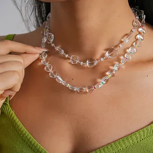 Dettaglio della collana a strati in perline di vetro trasparente con ciondoli a cuore.