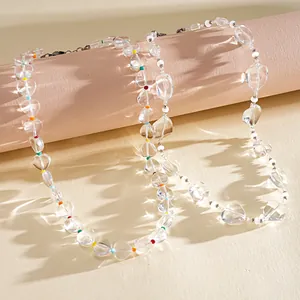 Vista dettagliata della collana in perle di vetro trasparente con accenti a cuore.
