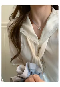 Détail d'un collier de perles avec un pendentif en forme de raisin sur un mannequin