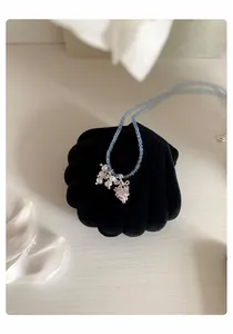 Détail d'un collier de perles avec pendentif raisin en cristal et grappe de perles