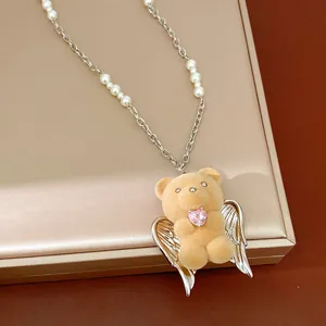 Dettaglio della collana con ciondolo orsetto floccato, perle e cuore rosa tenero