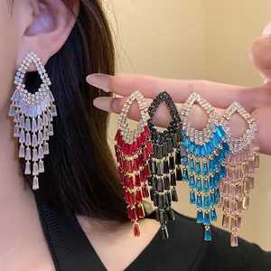 Dettaglio di orecchini con nappe di strass in vari colori come rosso, blu e rosa.