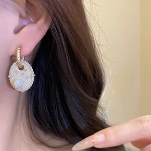 Elegante goldene Creolen mit echter Süßwasserperle und funkelnden Zirkonias