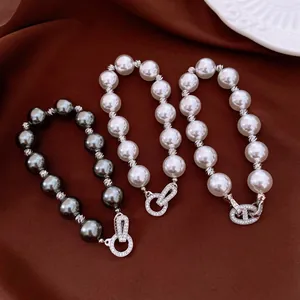 Detailansicht von drei Vintage-Perlenarmbändern mit funkelnden Zirkonia-Verschlüssen