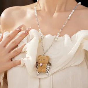 Primo piano di una collana di perle con ciondolo a forma di orso floccato con ali e cuore rosa