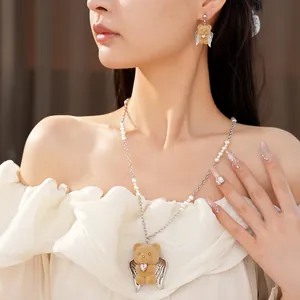 Dettaglio del ciondolo a forma di orso angelo con zircone a cuore e collana di perle