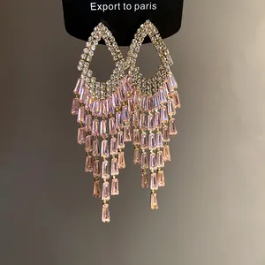 Primo piano di orecchini pendenti con cristalli rettangolari rosa e strass lucidi