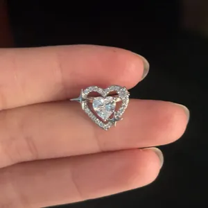 Elegant silver heart-shaped zircon ear cuff featuring star accents held on fingertips