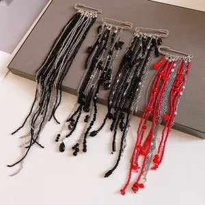 Detail of punk style long tassel safety pin brooches with red and black bead chains