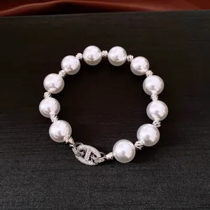 Detailansicht eines Vintage-Perlenarmbands mit einem funkelnden, zirkonbesetzten Verschluss.
