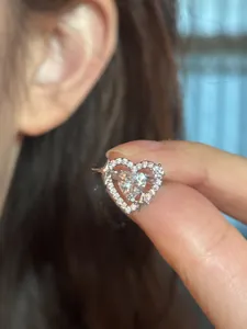 Detail of a silver heart-shaped ear cuff featuring star motifs and sparkling cubic zirconia.